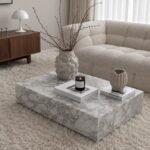 Low-profile white marble block coffee table with recessed tray top styled with vases
